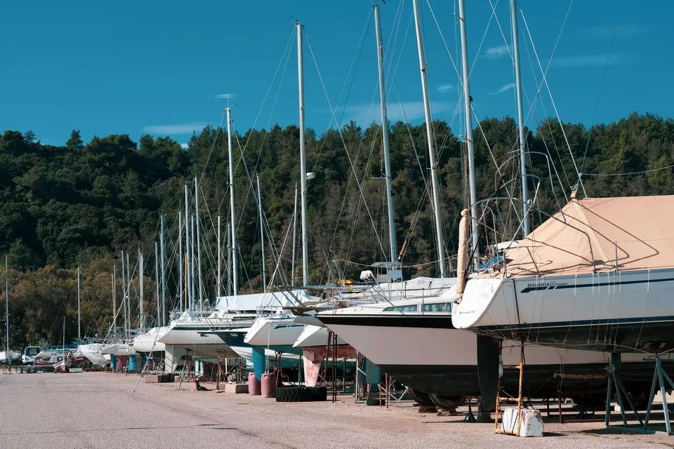 Voiliers stockés à terre, alignés sur une aire de chantier